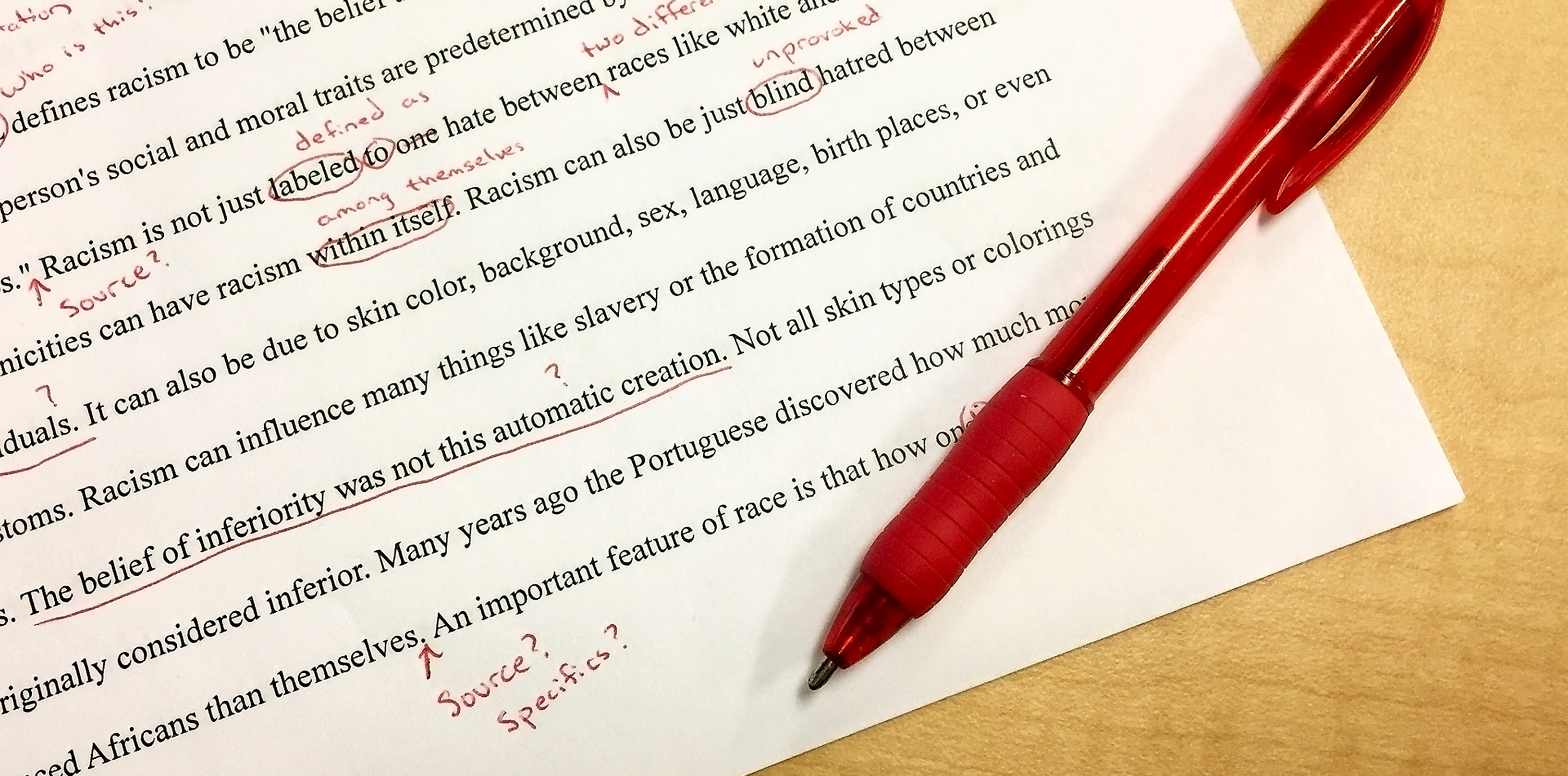 feedback in grad school. essay with a red pen resting on the page. comments and marks cover the paper, image by annekarakash on pixabay